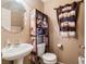 Clean bathroom with a pedestal sink, toilet, and decorative shelving at 9068 Alluring Ave, Las Vegas, NV 89149