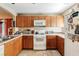 L-shaped kitchen with wood cabinets and gas range at 9068 Alluring Ave, Las Vegas, NV 89149