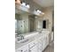 Bright bathroom features double sinks, white cabinets, a walk-in shower, and a large mirror at 12243 Pacific Cruise Ave, Las Vegas, NV 89138