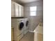 Functional laundry room with front loading washer and dryer plus storage cabinets at 12243 Pacific Cruise Ave, Las Vegas, NV 89138