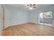 Bright bedroom featuring wood floors, ceiling fan, and sliding glass door to the outside at 1701 King James St # 101, Las Vegas, NV 89144