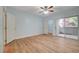 Bright bedroom featuring wood floors, ceiling fan, and sliding glass door to the outside at 1701 King James St # 101, Las Vegas, NV 89144