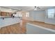 Bright open-plan living room with wood flooring and an adjoining kitchen with stainless steel appliances at 1701 King James St # 101, Las Vegas, NV 89144