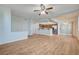 Open-plan living area with kitchen bar, stainless steel appliances, ceiling fan, and hardwood floors at 1701 King James St # 101, Las Vegas, NV 89144