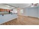 Bright living room with an open kitchen featuring wood-look floors and a ceiling fan at 1701 King James St # 101, Las Vegas, NV 89144