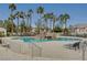 Community pool and lounging area with palm trees and decorative rock waterfall feature at 1701 King James St # 101, Las Vegas, NV 89144