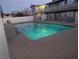 Community swimming pool at night with surrounding fence at 208 Orland St # 9, Las Vegas, NV 89107