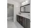 Modern bathroom with dark vanity, quartz countertop, and shower/tub combo at 25 Via Corvina, Henderson, NV 89011