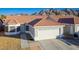 House exterior with a two-car garage, walkway and mountain views at 2594 Florida Keys Dr, Las Vegas, NV 89156