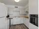 Modern kitchen with white cabinets, new appliances, and wood-look floors at 350 E Desert Inn Rd # H208, Las Vegas, NV 89109