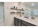 Bathroom featuring a double sink vanity, floating shelves and a large mirror at 495 Granite Arch St, Las Vegas, NV 89138