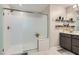 Bathroom with a glass shower door, a gray cabinet, a single sink, and floating shelves at 495 Granite Arch St, Las Vegas, NV 89138