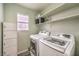 Bright laundry room with washer, dryer, and ample shelving at 7233 Tame Pl, Las Vegas, NV 89131