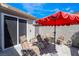 Relaxing patio with seating area, umbrella, and access to the house at 10487 Tyler Park Ave, Las Vegas, NV 89135