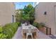 Outdoor patio with dining table, string lights, and lush greenery at 10712 Sheepshead Bay Ave, Las Vegas, NV 89166