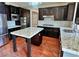 Kitchen island with granite countertop, dark wood cabinets, and hardwood floors at 316 Pleasant Summit Dr, Henderson, NV 89012