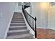 Elegant curved staircase with dark wood railing and carpeted steps at 316 Pleasant Summit Dr, Henderson, NV 89012