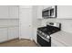 Close-up of the modern kitchen with stainless steel gas range and microwave, complemented by white cabinetry at 334 Taylor St, Henderson, NV 89015