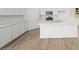 Modern kitchen with white cabinetry, a kitchen island, stainless steel appliances, and wood-look tile flooring at 334 Taylor St, Henderson, NV 89015