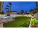 Inviting kidney-shaped pool with surrounding grass and palm trees at 336 Merit Ct, Henderson, NV 89014