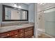 Bathroom with granite countertop, wood cabinets, and a shower at 3817 Bach Way, North Las Vegas, NV 89032