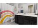 Bathroom with rainbow shower curtain and dark vanity at 6301 Beavertail Pond Ave, Las Vegas, NV 89122