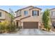 Two-story house with brown garage door and landscaping at 6301 Beavertail Pond Ave, Las Vegas, NV 89122