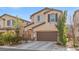 Two-story house with a brown garage door and landscaping at 6301 Beavertail Pond Ave, Las Vegas, NV 89122