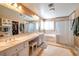 Elegant bathroom with double sinks, a bathtub, and a walk-in shower at 6516 Starling Mesa St, North Las Vegas, NV 89086