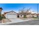 Single story home with a two-car garage and mature trees at 1665 Rowan Tree Dr, Las Vegas, NV 89123