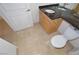 Compact bathroom featuring dual sinks with dark countertop, and neutral tile flooring at 270 E Flamingo Rd # 211, Las Vegas, NV 89169