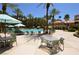 Resort-style pool area features lounge seating and table seating under mature palm trees at 270 E Flamingo Rd # 211, Las Vegas, NV 89169