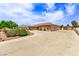 Long driveway leading to a residence with an attached garage and well manicured desert landscaping at 2730 El Camino Rd, Las Vegas, NV 89146