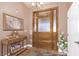 Welcoming entryway with a decorative front door, chandelier, and elegant console table at 2730 El Camino Rd, Las Vegas, NV 89146