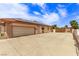 Side exterior view featuring an attached garage with a large drive and gate, enhanced by solar panels at 2730 El Camino Rd, Las Vegas, NV 89146