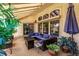 Cozy covered patio with a fire pit table, comfortable seating, and well-placed plants at 2730 El Camino Rd, Las Vegas, NV 89146