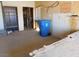 Unfinished garage space with shelving and a blue recycling bin at 3748 Skyline St, Logandale, NV 89021