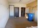 Unfinished garage with storage and a blue recycling bin at 3748 Skyline St, Logandale, NV 89021