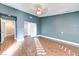 Serene bedroom with wood-look floors, blue walls, and a ceiling fan at 6401 Home Run Dr, Las Vegas, NV 89130