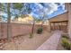 Landscaped backyard with paved pathway and covered patio at 7642 Riva Ridge St, Las Vegas, NV 89149