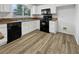 Modern kitchen with black appliances and wood-look floors at 8509 Goodhaven Dr, Las Vegas, NV 89134