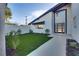 Landscaped front yard with artificial turf and walkway leading to modern front door at 8645 Edmond St, Las Vegas, NV 89139