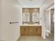 Elegant bathroom with dual sinks, backlit mirrors, and light wood cabinets at 9524 Sundial Dr, Las Vegas, NV 89134