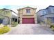 Two-story house with a red garage door and landscaped front yard at 10830 Lexus Ct, Las Vegas, NV 89141