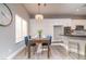 Bright dining area with wooden table, blue chairs, and a chandelier at 1240 Honey Lake St, Las Vegas, NV 89110