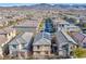 An aerial view shows a neighborhood with neatly arranged houses and solar panels, set against a mountain backdrop at 2694 Marvel Astoria St, Henderson, NV 89044