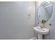 Bathroom with pedestal sink, decorative mirror, and neutral color palette at 2694 Marvel Astoria St, Henderson, NV 89044