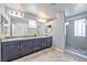 Bathroom featuring double sinks, neutral walls, and a walk-in shower with a frosted window at 2694 Marvel Astoria St, Henderson, NV 89044