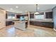 Spacious kitchen with dark cabinetry, granite countertops, stainless steel appliances and large island at 2694 Marvel Astoria St, Henderson, NV 89044