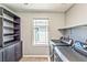 This laundry room features built in shelving, folding station, and a window for natural light at 2694 Marvel Astoria St, Henderson, NV 89044